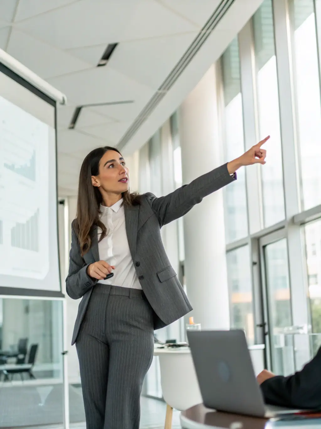 A person confidently presenting to a small audience in a modern conference room in Edinburgh, demonstrating strong public speaking skills and leadership presence.